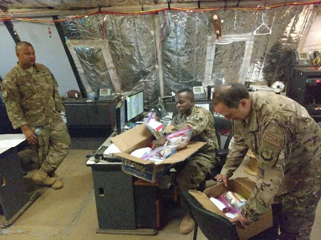 man leaning down opening care package