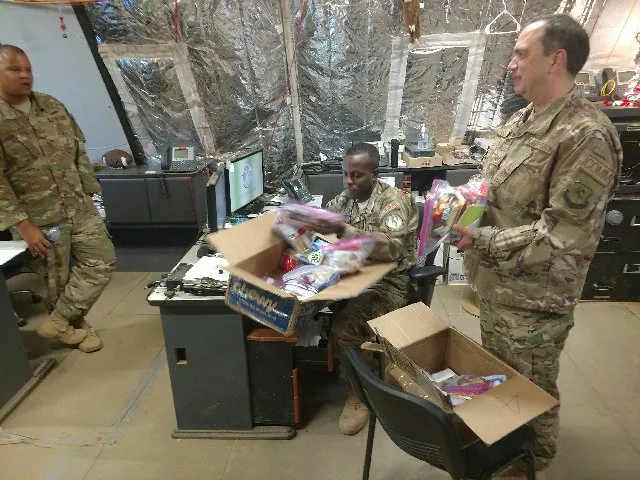 soldiers in army office opening christmas presents