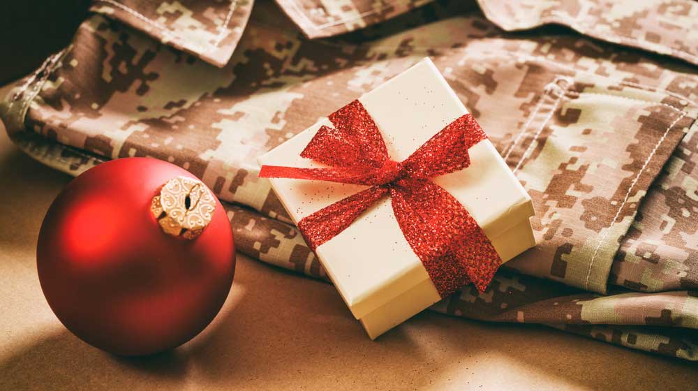 Christmas in the army concept. Christmas ball and gift box on an American soldier uniform