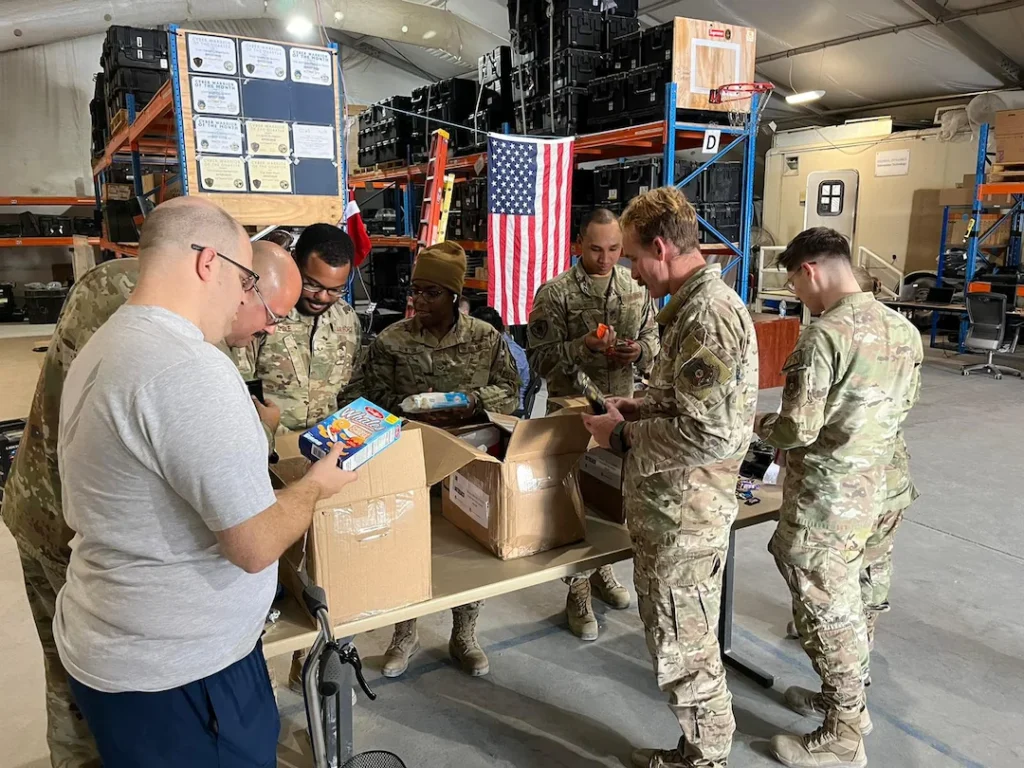 group of soldiers opening care package